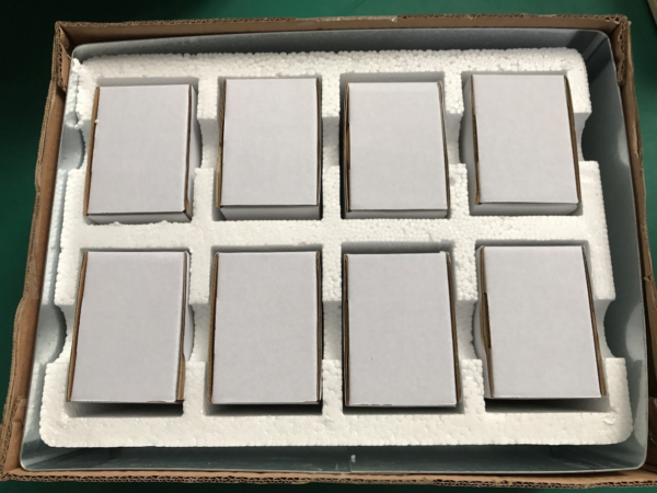 Fig. 4 - The 'small white box' being placed in a foam-filled cardboard box, with iron sheets surrounding the bottom and sides